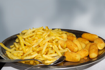 French fries and croquettes on plate in restaurant isolated