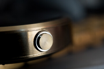 Macro closeup photo of metallic button of a golden wrist watch with circles.
