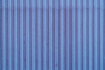 texture of a shaped fence made of blue metal. the metal sheet is covered with frost