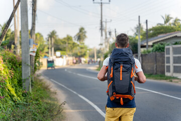 Young backpacker walks on Asian street