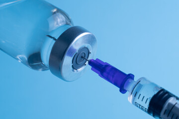 Close-up of filling a syringe with vaccine. A syringe with a needle draws the medicine.