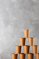 Brown paper cups stacked, white wall background