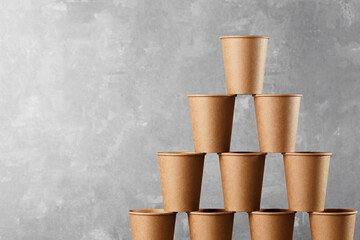 Brown paper cups stacked, white wall background