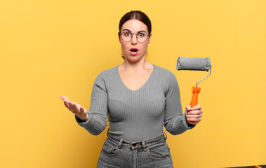young pretty woman open-mouthed and amazed, shocked and astonished with an unbelievable surprise