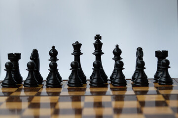 Set of black chess pieces on a chess board