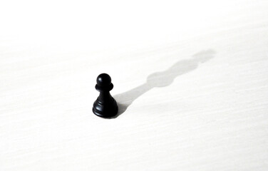 Black pawn with the shadow of a king as a symbol of self confidence