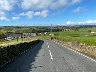 View down, Back Lane, with dry stone walls, fields, farms and distant hills near, Bradford, Yorkshire, UK