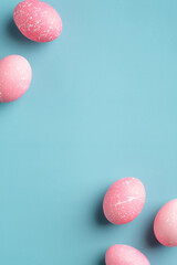 Happy easter minimal concept. Flat lay, top view pink Easter eggs on turquoise background. Vertical...