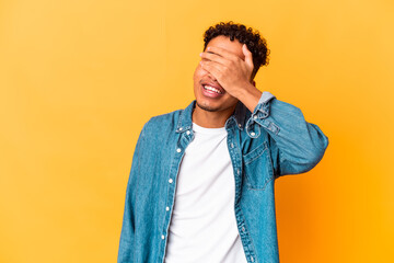 Young african american curly man isolated on purple covers eyes with hands, smiles broadly waiting for a surprise.