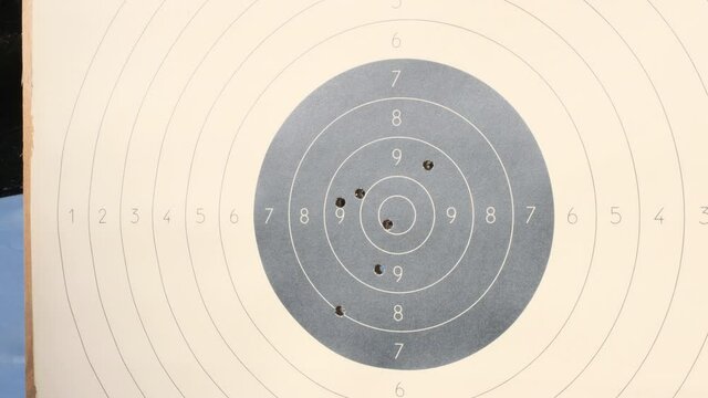 The target for shooting is pierced by bullets in the shooting range. Target for practical pistol shooting with bullet holes. Range shooting practice.