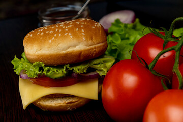 Burger and tomatoes on the table. Making burgers at home. Fast food.