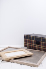 Pudełko tekturowe w kratę i ramki jasne drewniane © Seance_Photo_Sylwia