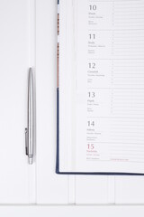 Kalendarz i długopis na białym biurku
