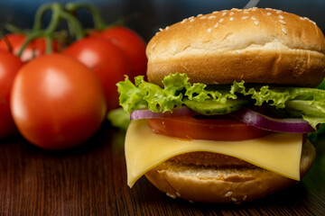 Burger and tomatoes on the table. Making burgers at home. Fast food.