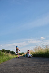 identical twin sisters having fun with their scateboards on a sunny summer day