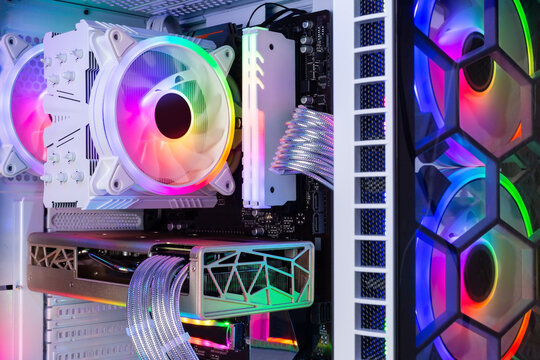 Inside view of custom colorful illuminated bright rainbow RGB LED gaming pc. Computer power hardware and technology concept background