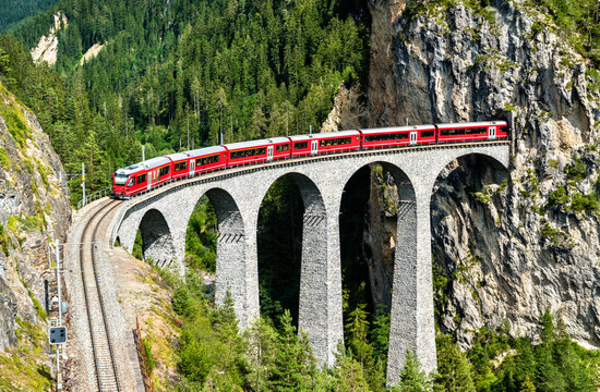 Passenger train crossing the Landwasser Viaduct in the Swiss Alps