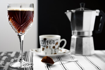 Espresso martini in an crystal glass with coffee cup and cafetiere