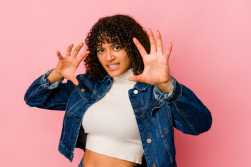 Young african american afro woman isolated upset screaming with tense hands.