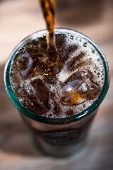 Cola poured into a glass filled with ice
