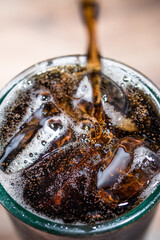 Cola poured into a glass filled with ice