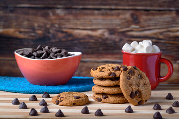 Chocochips cookies with wood background and red cup