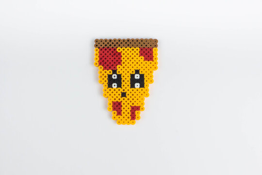 Perler bead pizza slice. White isolated background.