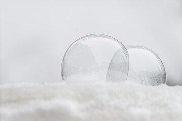Two frozen soap bubbles freezing of low temperature under zero on snow