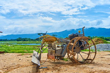 A strange homemade tool for plowing a field from a rebuilt motorbike. Agricultural village in Asia