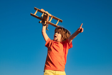 Kid pilot with toy airplane against sky background. Happy child playing outdoors. Happy childhood. Daydreaming. Kids dreams.