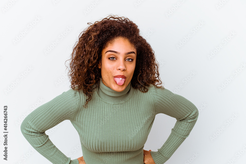 Wall mural young african american woman isolated on white background funny and friendly sticking out tongue.