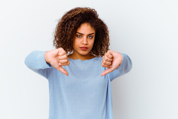 Young african american woman isolated on white background showing a dislike gesture, thumbs down....