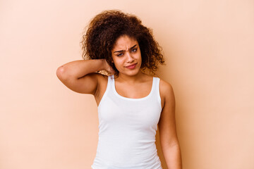 Young african american woman isolated on beige background suffering neck pain due to sedentary lifestyle.