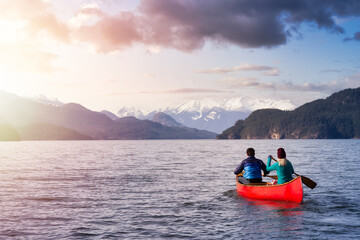 Couple friends canoeing on a wooden canoe during a sunny day. Colorful Sunset Sky Art Render. Taken in Harrison Lake, East of Vancouver, British Columbia, Canada.