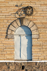 the door in the form of an arch is closed with a sheet of iron. old textured brick building