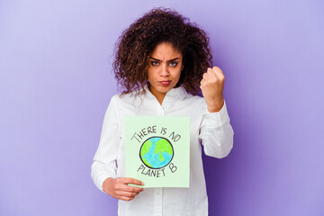 Young African American woman holding a There is no planet B placard isolated showing fist to camera, aggressive facial expression.