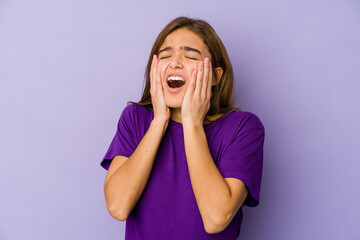 Young skinny caucasian girl teenager on purple background whining and crying disconsolately.