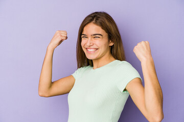 Young skinny caucasian girl teenager on purple background cheering carefree and excited. Victory concept.