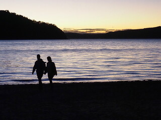 Two People Walking In Sunset