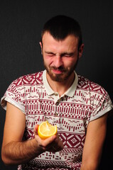 a guy with a beard eating lemon