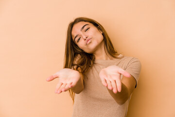 Young skinny caucasian teenager girl folding lips and holding palms to send air kiss.