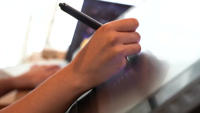 Close up on a young lady's hand using a graphic drawing tablet.