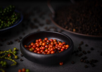 selective focus,red pepper in black cup on dark background,with black pepper background
