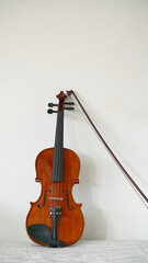 Naklejka na ściany i meble A violin and bow against the wall, string instrument on white background