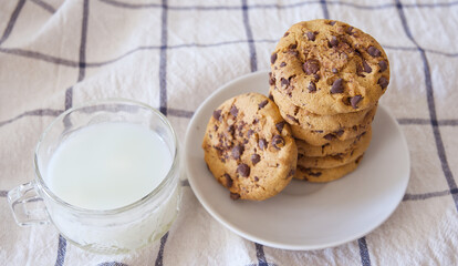 A plate of chocolate cookies and a glass of milk on the table, breakfast concept
