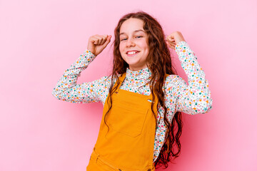 Little caucasian girl isolated on pink background cheering carefree and excited. Victory concept.