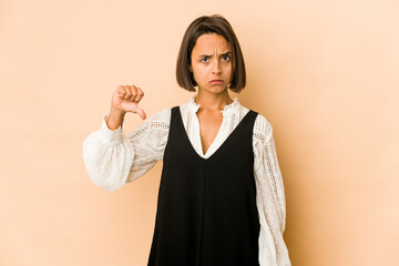 Young hispanic woman isolated showing a dislike gesture, thumbs down. Disagreement concept.