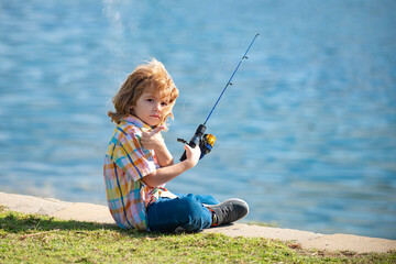 Child fishing on the lake. Young fisher. Boy with spinner at river. Portrait of excited boy...