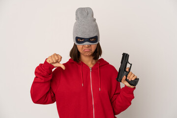 Young robber hispanic woman wearing a mask showing a dislike gesture, thumbs down. Disagreement concept.
