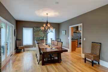 Beautiful luxury diningroom with wood and wicker chairs and hardwood floors and table.